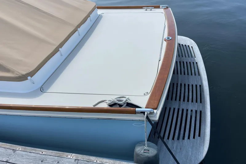 Sea Glass Yacht Photos Pics 2015 CH Marine Shelter Island Runabout, docked with beige cover and wooden trim.