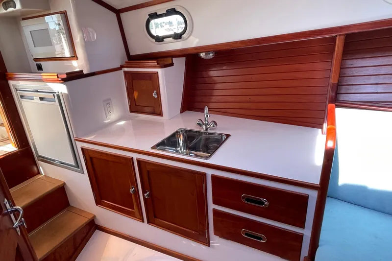 Sea Glass Yacht Photos Pics 2015 CH Marine Shelter Island Runabout interior with wooden cabinetry and compact kitchenette.