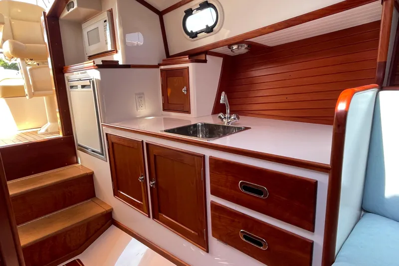Sea Glass Yacht Photos Pics 2015 CH Marine Shelter Island Runabout interior with wooden cabinetry and compact kitchen area.