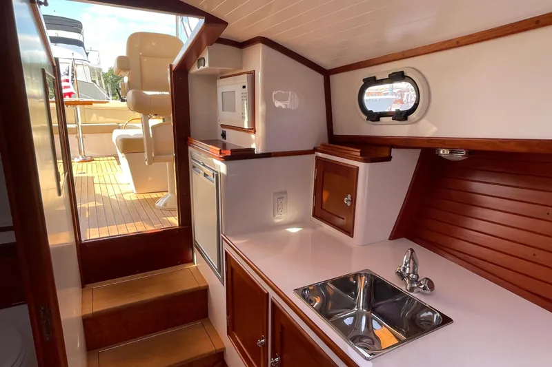 Sea Glass Yacht Photos Pics 2015 CH Marine Shelter Island Runabout interior with kitchenette, sink, and wooden cabinetry.