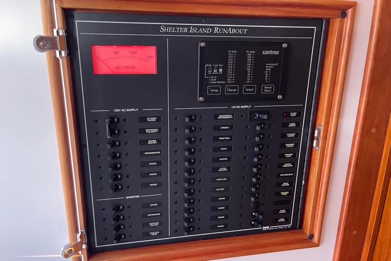 Sea Glass Yacht Photos Pics Electrical control panel of 2015 CH Marine Shelter Island Runabout boat, featuring AC and DC supply switches.