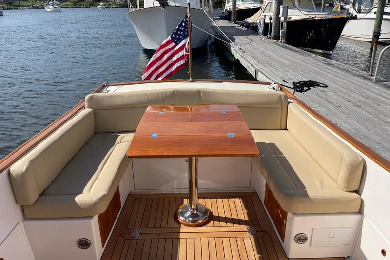 Sea Glass Yacht Photos Pics 2015 CH Marine Shelter Island Runabout with elegant seating and wooden table, docked by the water.