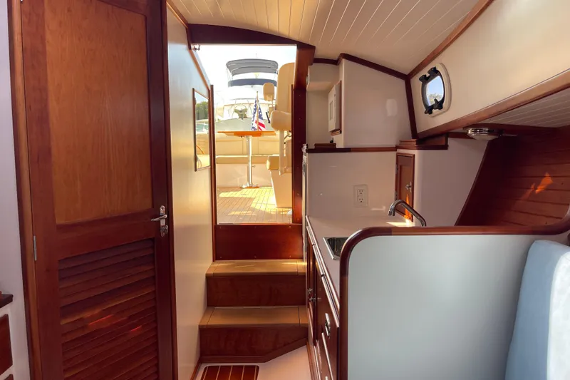 Sea Glass Yacht Photos Pics 2015 CH Marine Shelter Island Runabout interior with wooden cabinetry and compact kitchen area.