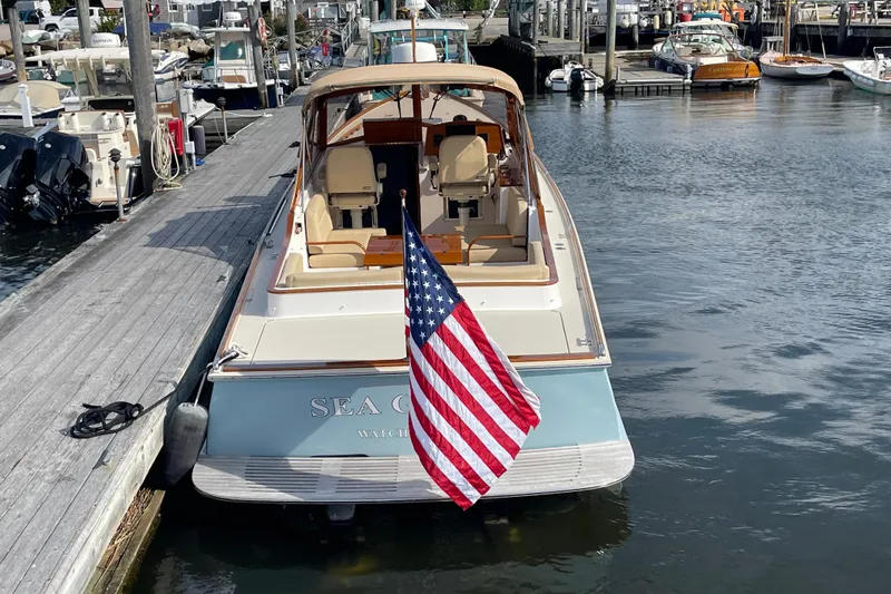 Sea Glass Yacht Photos Pics 2015 CH Marine Shelter Island Runabout docked, displaying American flag, in a marina setting.