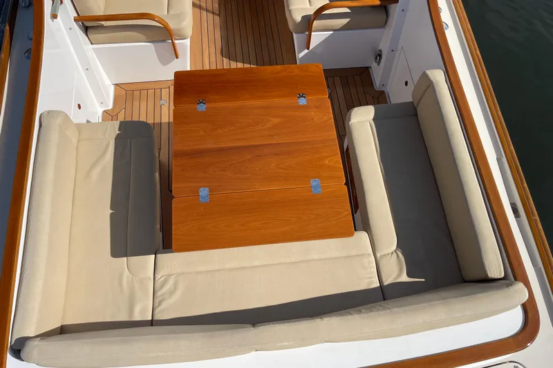 Sea Glass Yacht Photos Pics 2015 CH Marine Shelter Island Runabout interior with wooden table and beige seating.