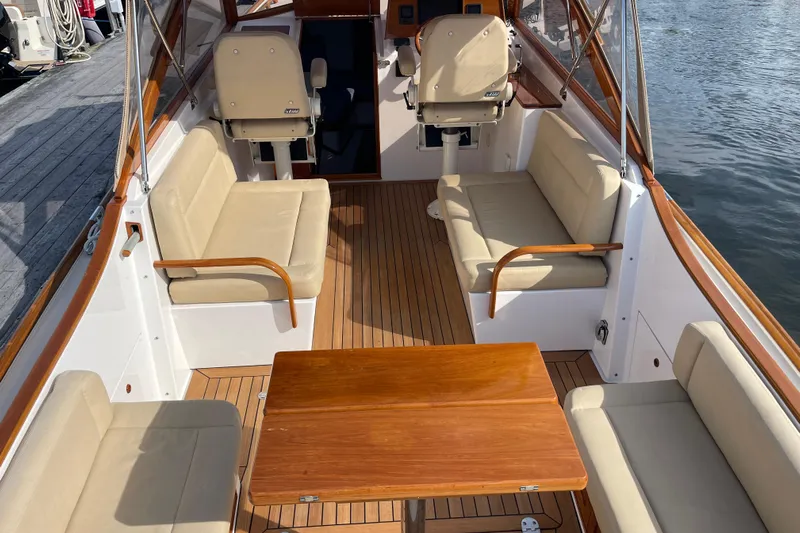 Sea Glass Yacht Photos Pics 2015 CH Marine Shelter Island Runabout interior with beige seating and wooden table.