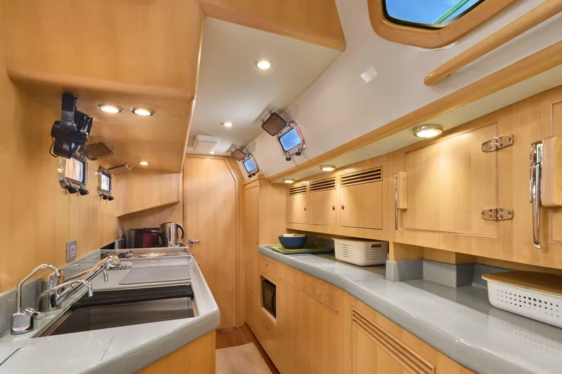 Cinchona Yacht Photos Pics Luxurious 2020 Outbound 52 yacht interior kitchen with modern amenities and wooden cabinetry.