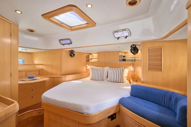 Cinchona Yacht Photos Pics Luxurious cabin interior of 2020 Outbound 52 yacht with cozy bed and seating area.