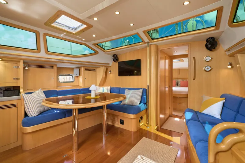 Cinchona Yacht Photos Pics Luxurious interior of 2020 Outbound 52 yacht with blue seating and wooden finishes.