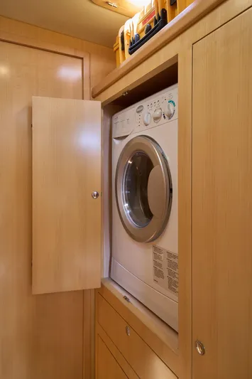 Cinchona Yacht Photos Pics Compact laundry area with a front-loading washer in a 2020 Outbound 52 yacht.