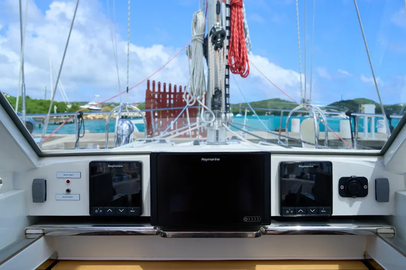Cinchona Yacht Photos Pics Cockpit view of 2020 Outbound 52 sailboat with navigation screens and marina backdrop.