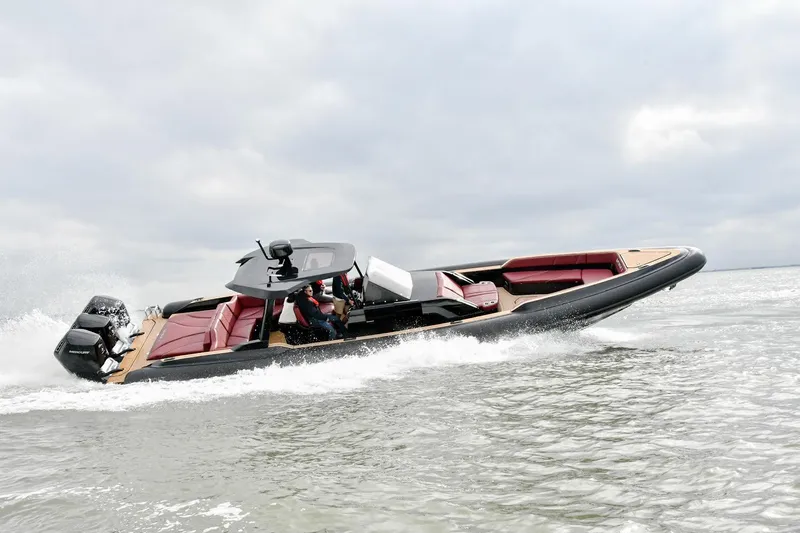  Yacht Photos Pics 2023 Revolt Comfort 47 boat cruising on water with red seating and dual engines.