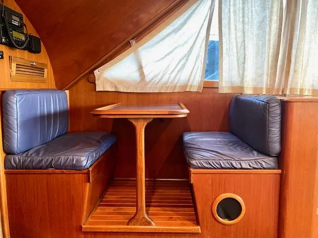 Woodcutter Yacht Photos Pics Cozy dining area on 2000 Custom Carolina 56 East Bay boat with blue cushions.