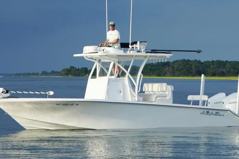  Yacht Photos Pics 2022 SeaHunter 28 Floridian boat on calm water with a person at the helm.