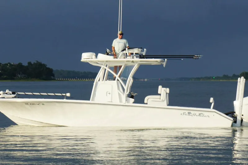  Yacht Photos Pics 2022 SeaHunter 28 Floridian boat on calm water with a person standing on deck.