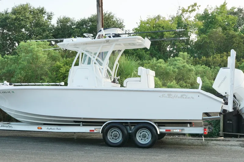  Yacht Photos Pics 2022 SeaHunter 28 Floridian boat on trailer, surrounded by lush greenery.