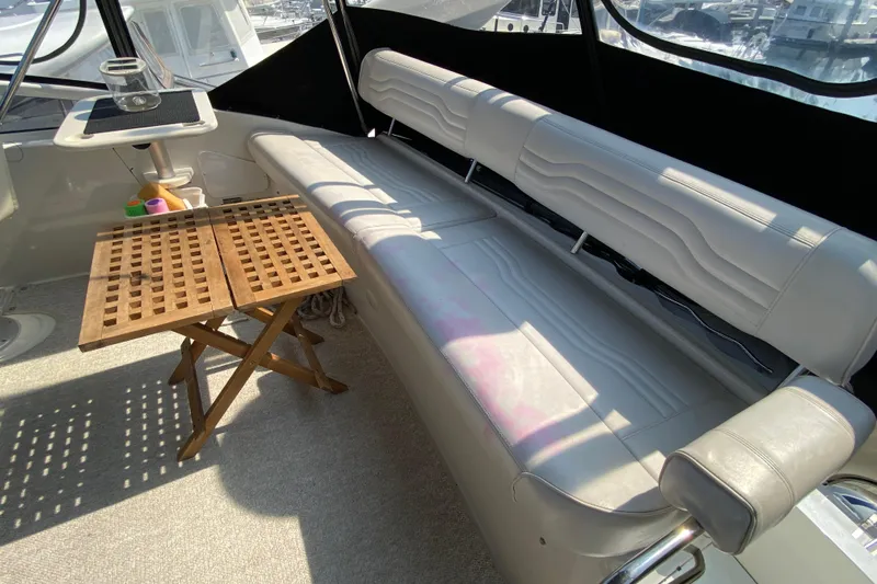 Slippin Out Yacht Photos Pics 2004 Carver 36 Super Sport yacht interior with cushioned seating and wooden table.