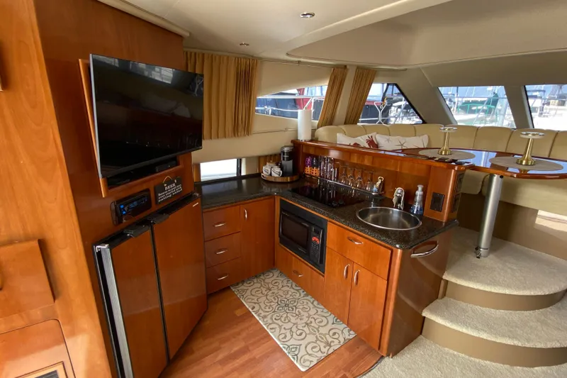 Slippin Out Yacht Photos Pics Luxurious interior of 2004 Carver 36 Super Sport yacht with kitchenette and seating area.