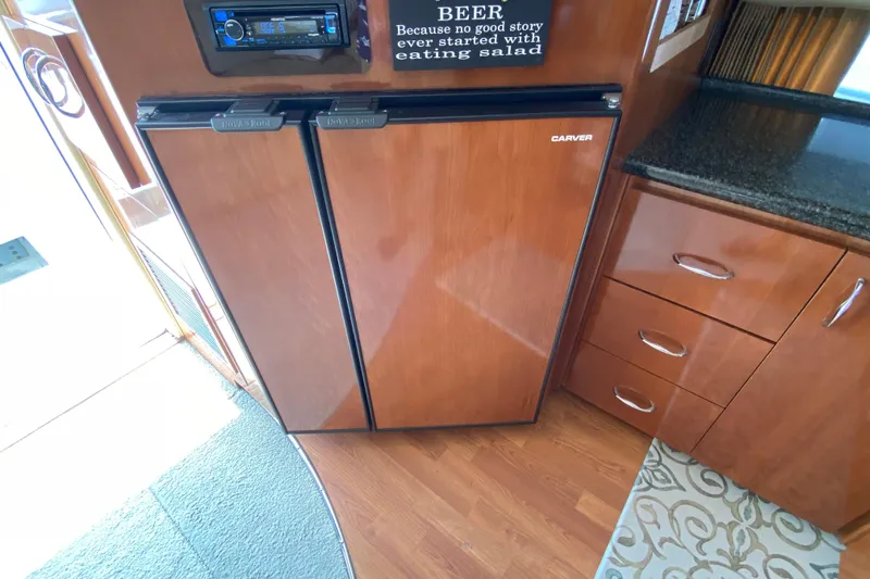 Slippin Out Yacht Photos Pics 2004 Carver 36 Super Sport interior with wood cabinetry and built-in refrigerator.