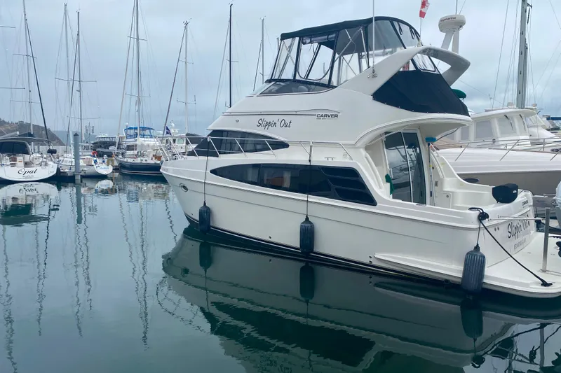 Slippin Out Yacht Photos Pics 2004 Carver 36 Super Sport yacht docked in a marina, surrounded by sailboats.