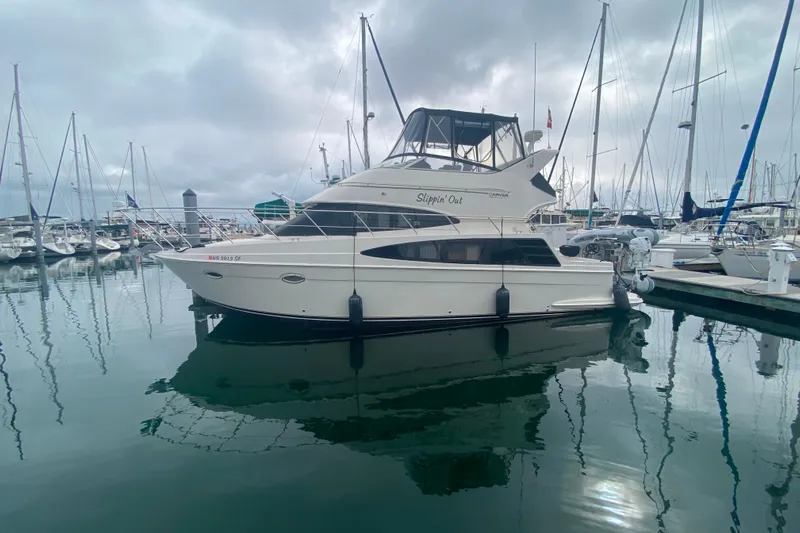 Slippin Out Yacht Photos Pics 2004 Carver 36 Super Sport yacht docked in a marina, reflecting on calm water.