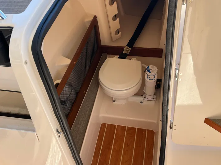  Yacht Photos Pics 2023 Grady-White Freedom 275 boat interior with compact marine toilet.