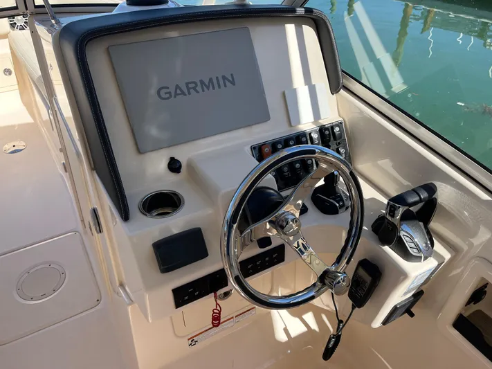  Yacht Photos Pics 2023 Grady-White Freedom 275 boat dashboard with Garmin navigation system and steering wheel.