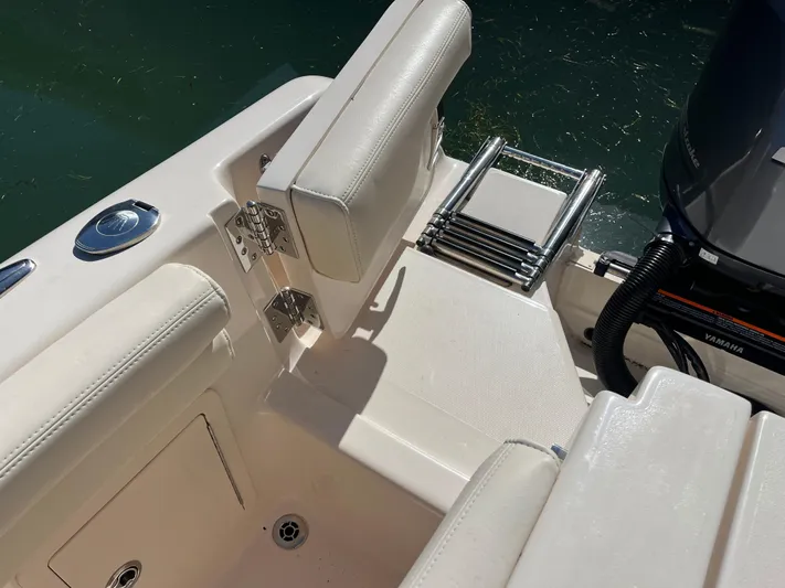  Yacht Photos Pics 2023 Grady-White Freedom 275 boat interior with seating and ladder near water.