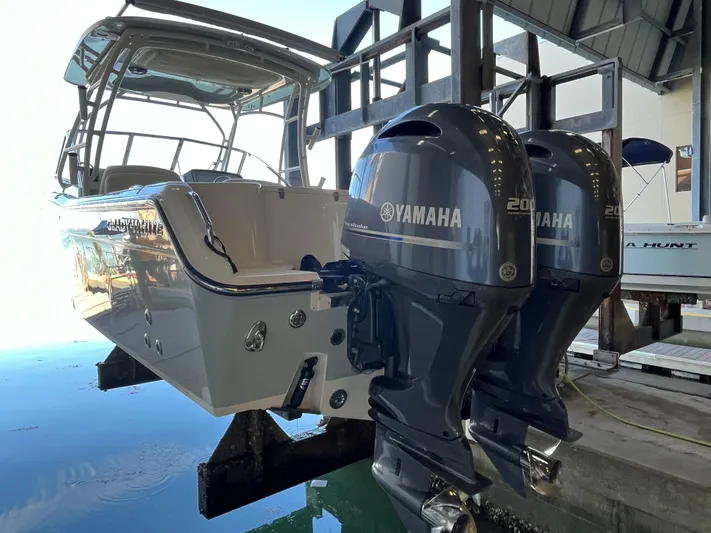  Yacht Photos Pics 2023 Grady-White Freedom 275 boat with dual Yamaha 200 engines in a marina setting.