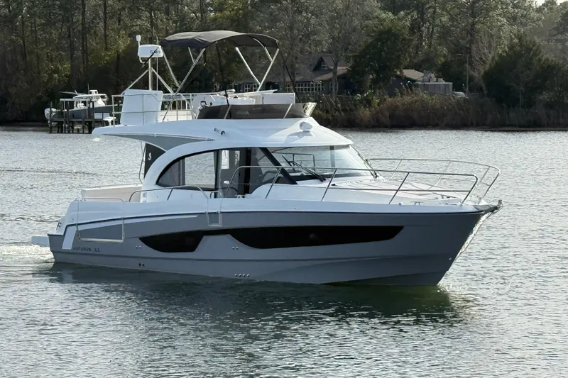  Yacht Photos Pics 2026 Beneteau Antares 11 Fly yacht cruising on a serene waterway.