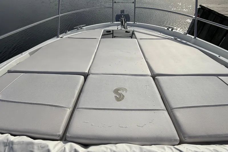  Yacht Photos Pics 2026 Beneteau Antares 11 Fly deck with cushioned sunbathing area, overlooking calm water.