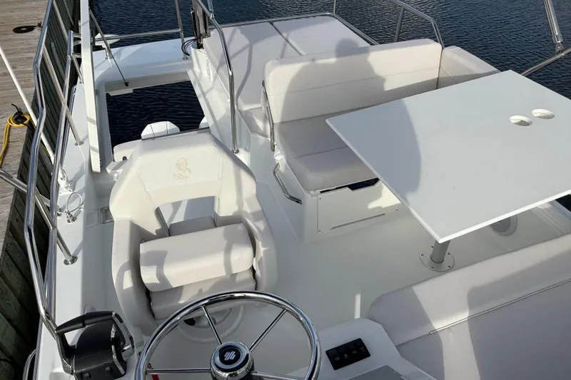  Yacht Photos Pics Flybridge of 2026 Beneteau Antares 11 Fly with seating and table, docked by water.