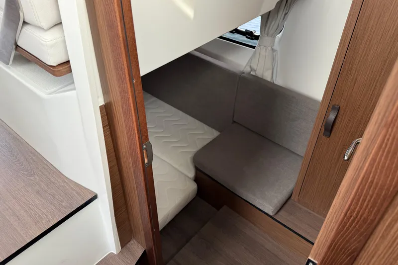  Yacht Photos Pics 2026 Beneteau Antares 11 Fly cabin interior with cozy seating and wooden finishes.