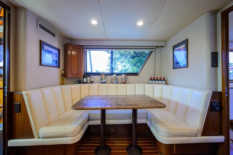 Forever Young Yacht Photos Pics Interior of 1991 Hatteras 78 CMY yacht with cozy dining nook and window view.