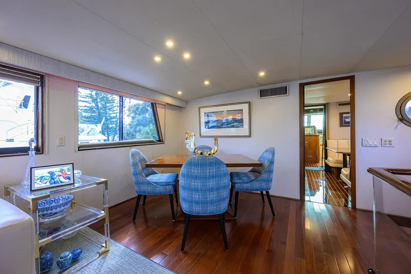 Forever Young Yacht Photos Pics Luxurious interior of 1991 Hatteras 78 CMY yacht with elegant dining area and blue chairs.