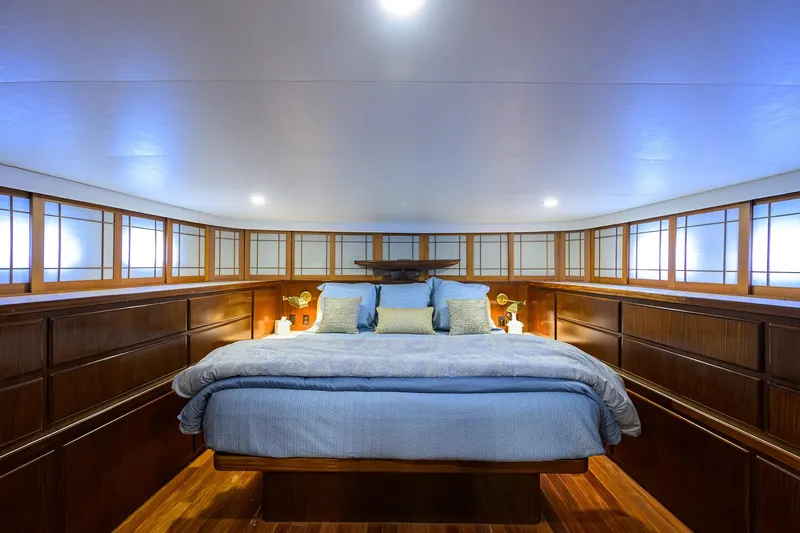 Forever Young Yacht Photos Pics Luxurious bedroom interior on 1991 Hatteras 78 CMY yacht with elegant wood paneling.