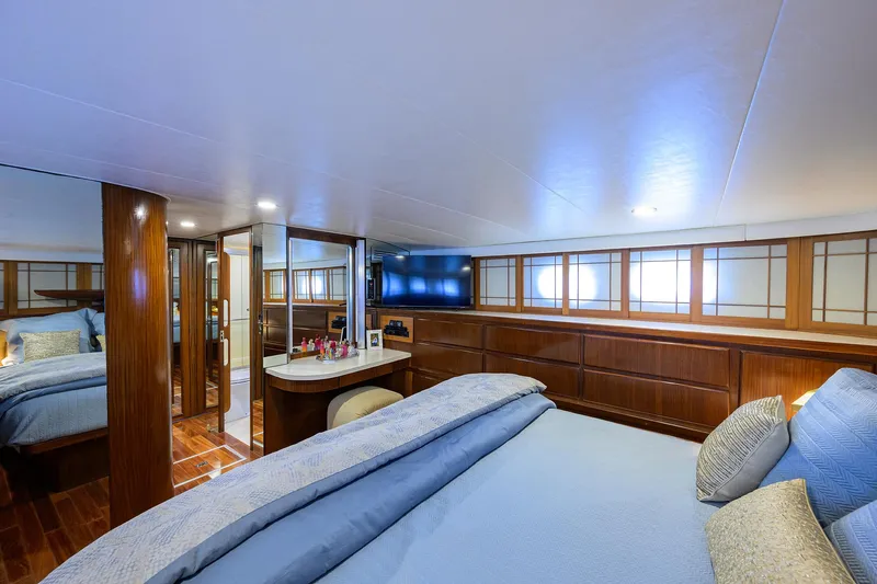 Forever Young Yacht Photos Pics Luxurious bedroom interior of 1991 Hatteras 78 CMY yacht with elegant wood finishes.