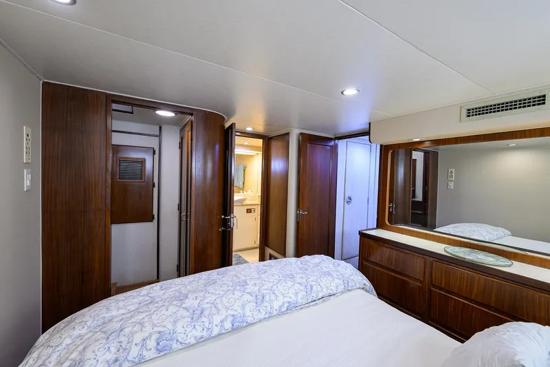 Forever Young Yacht Photos Pics Luxurious bedroom interior on 1991 Hatteras 78 CMY yacht with wood accents and modern amenities.