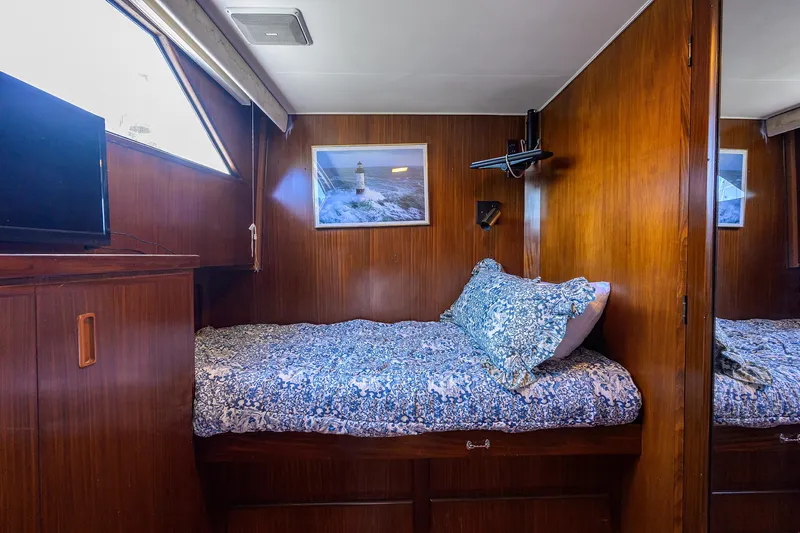 Forever Young Yacht Photos Pics Cozy cabin interior of 1991 Hatteras 78 CMY yacht with wooden paneling and single bed.