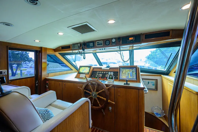 Forever Young Yacht Photos Pics Interior of 1991 Hatteras 78 CMY yacht with wooden helm and navigation equipment.