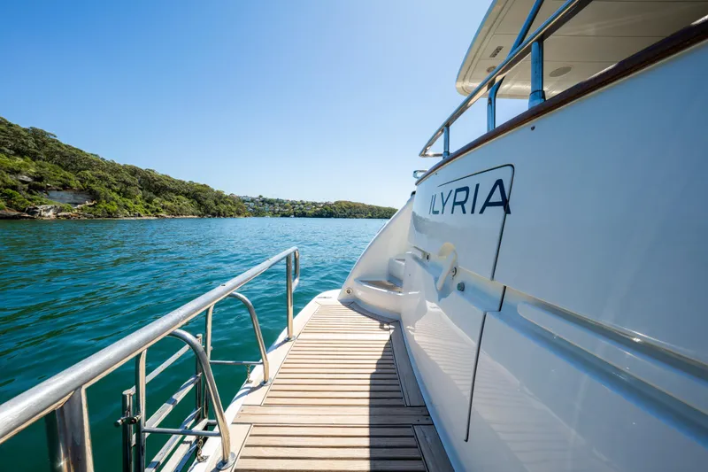 Ilyria Yacht Photos Pics Sanlorenzo SL72 yacht, 2007 model, docked on serene blue waters with lush greenery.