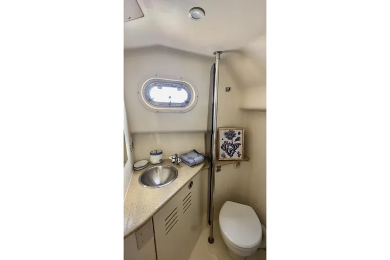 Bay'be Yacht Photos Pics 2009 Mainship Pilot 31 boat bathroom with sink, toilet, and porthole window.