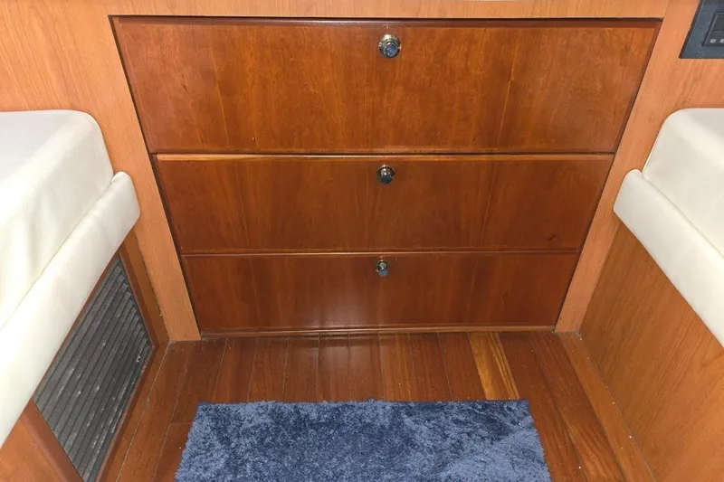 Bay'be Yacht Photos Pics Interior of 2009 Mainship Pilot 31 with wooden drawers and blue rug.