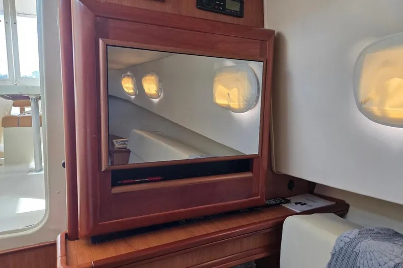 Bay'be Yacht Photos Pics Interior of 2009 Mainship Pilot 31 with wooden cabinetry and cozy seating area.