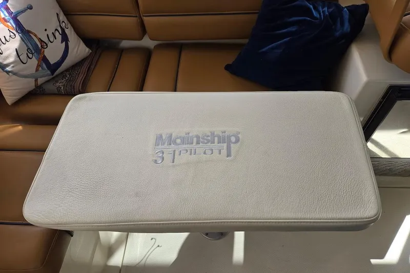 Bay'be Yacht Photos Pics 2009 Mainship Pilot 31 interior with cushioned table and nautical-themed decor.