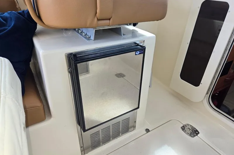 Bay'be Yacht Photos Pics 2009 Mainship Pilot 31 interior with compact refrigerator and tan seating.