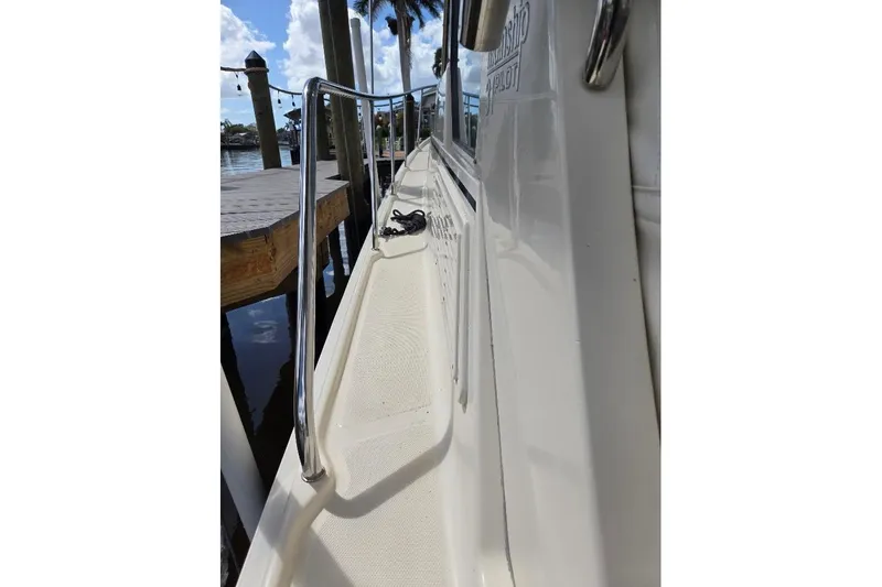 Bay'be Yacht Photos Pics 2009 Mainship Pilot 31 boat deck with railing, docked by the water.
