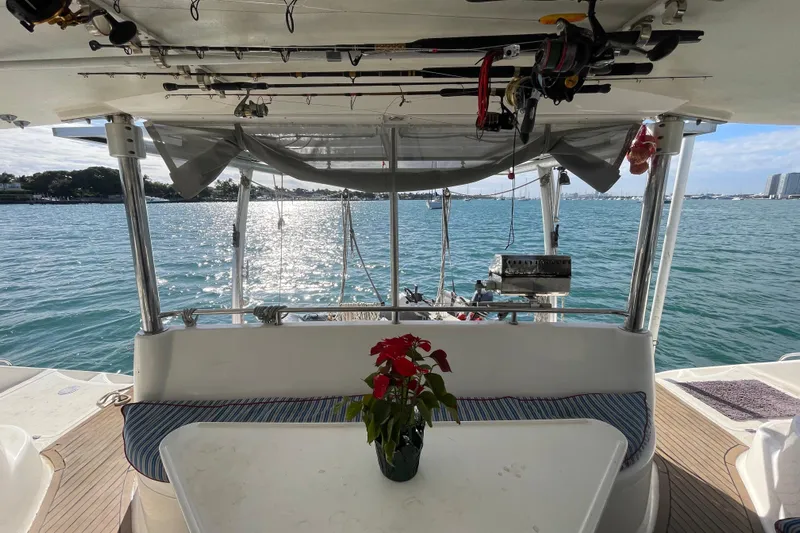 Nadi Yacht Photos Pics Knysna 480 yacht interior with ocean view, fishing rods, and potted plant on table.