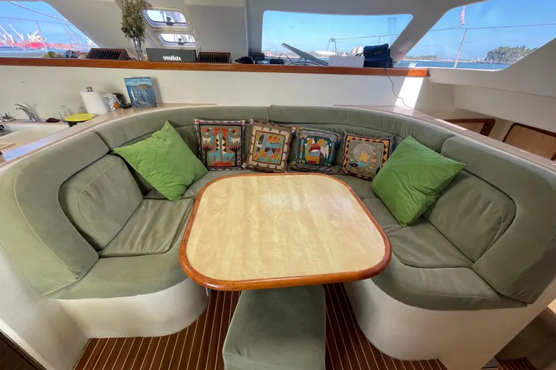 Nadi Yacht Photos Pics Cozy seating area on 2010 Knysna 480 yacht with green cushions and decorative pillows.