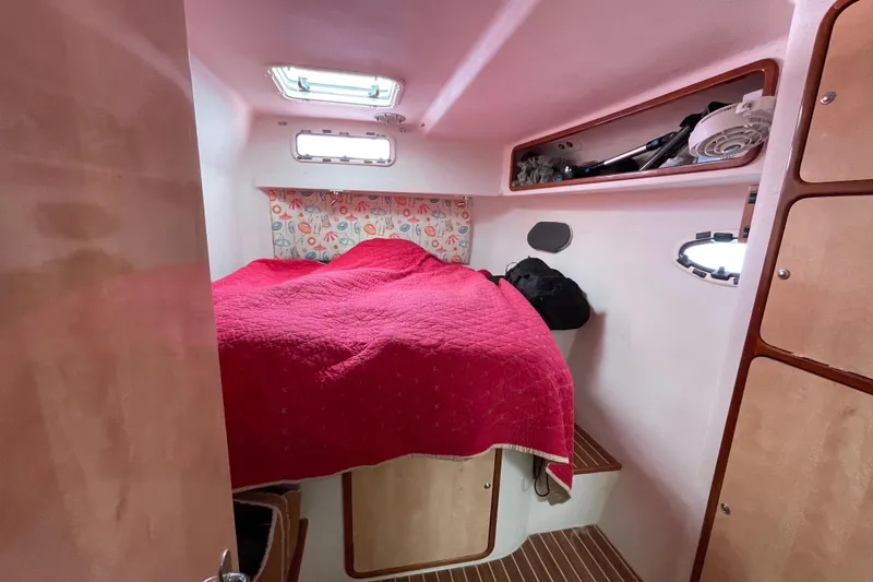 Nadi Yacht Photos Pics Cozy cabin interior of 2010 Knysna 480 yacht with red bedding and wooden accents.